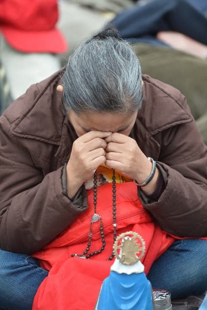 Una mujer reza el santo Rosario previo a la ceremonia de canonización. Fieles provenientes de todo el mundo asistieron a la ceremonia para pedir la intersección de los dos nuevos santos.