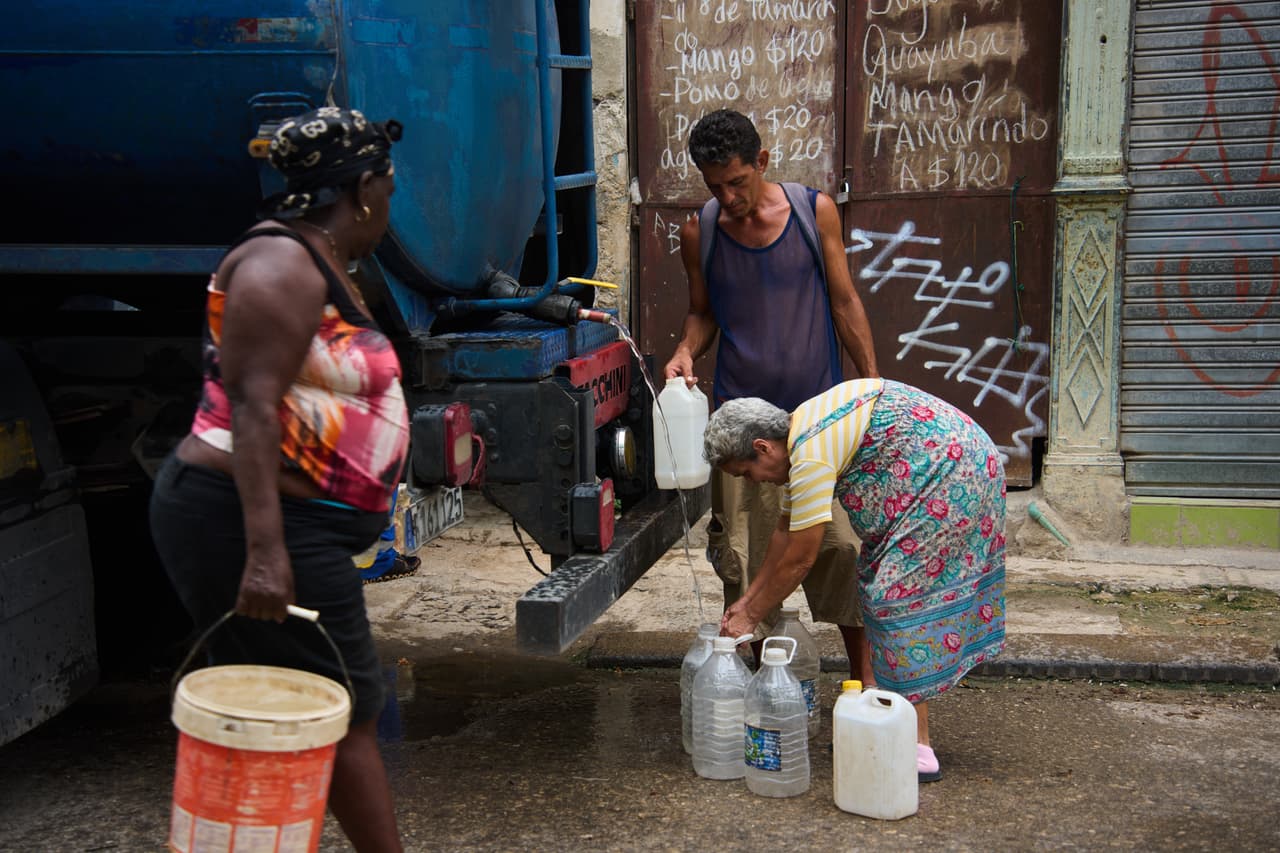 Personas llenan garrafas con agua en La Habana, Cuba, el viernes 12 de junio de 2026. (Foto AP/Ramon Espinosa)