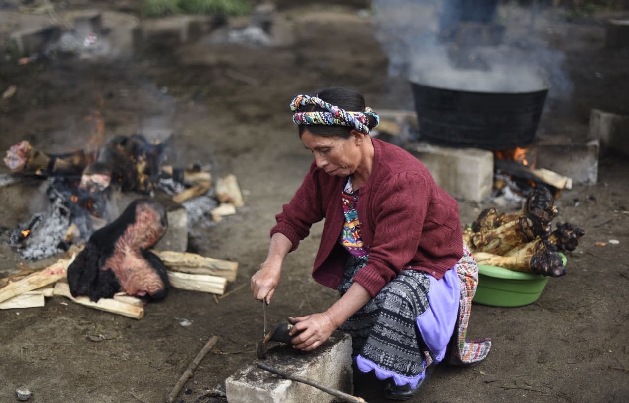 Una mujer del pueblo trabajando para poder alimentar a todos los asistentes al funeral.