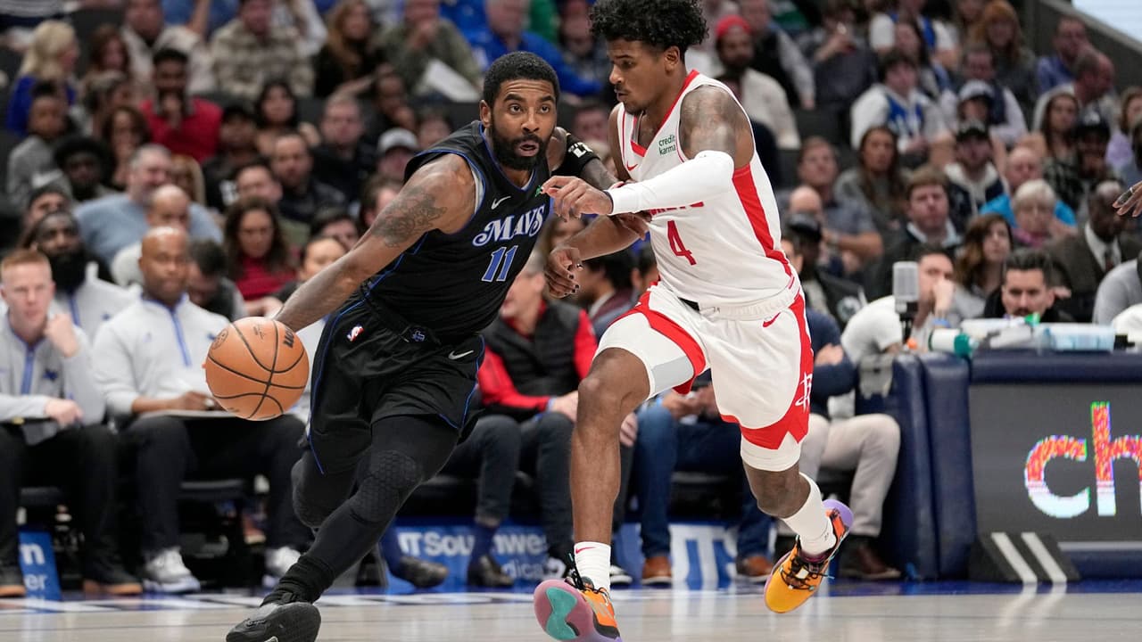 Kyrie Irving (11), de los Mavericks de Dallas, se enfila a la canasta mientras tiene la marca defensiva de Jalen Green (4), de los Rockets de Houston, en la segunda mitad del juego de baloncesto de la NBA, en Dallas, el martes 28 de noviembre de 2023.
