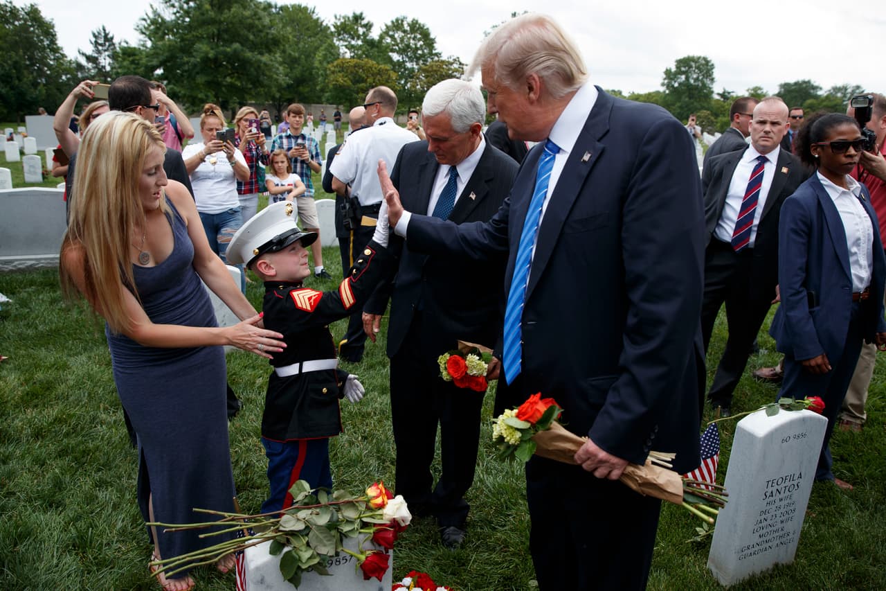Brittany Jacobs y su hijo de seis años Christian Jacobs saludan al presidente Trump y al vicepresidente Pence durante su recorrido por el Cementerio Nacional de Arlington. (AP/Evan Vucci)