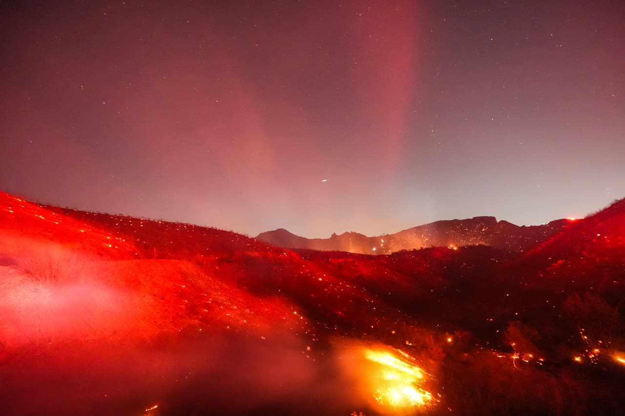 Puntos de calor resplandecen en una ladera durante el incendio de Bryson en Malibú, California, el jueves 15 de octubre de 2026.