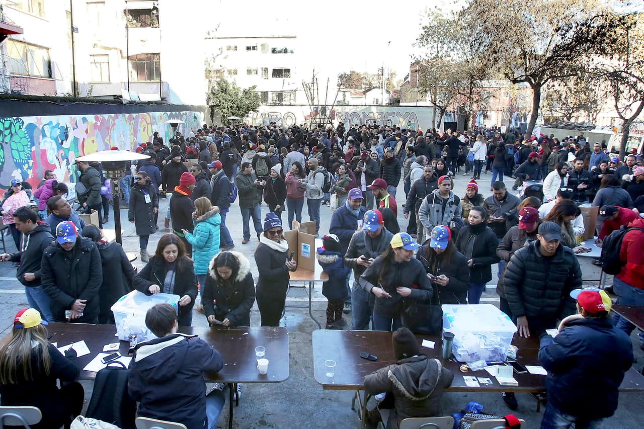 Según el informe de la OIM, al menos
<a href="https://www.univision.com/noticias/emigracion/venezolanos-huyen-a-chile-en-un-riesgoso-viaje-de-carretera-y-rios-de-nueve-dias">119,051 han migrado a Chile</a>. Entre el 2015 y 2017 ese país otorgó más de 120,000 permisos de residencia a venezolanos, el 75% solicitadas en Santiago, la capital. En la fotografía, cientos de venezolanos reunidos en Santiago de Chile para votar contra la Asamblea Nacional Constituyente propuesta por el gobierno de Venezuela, en julio de 2017.