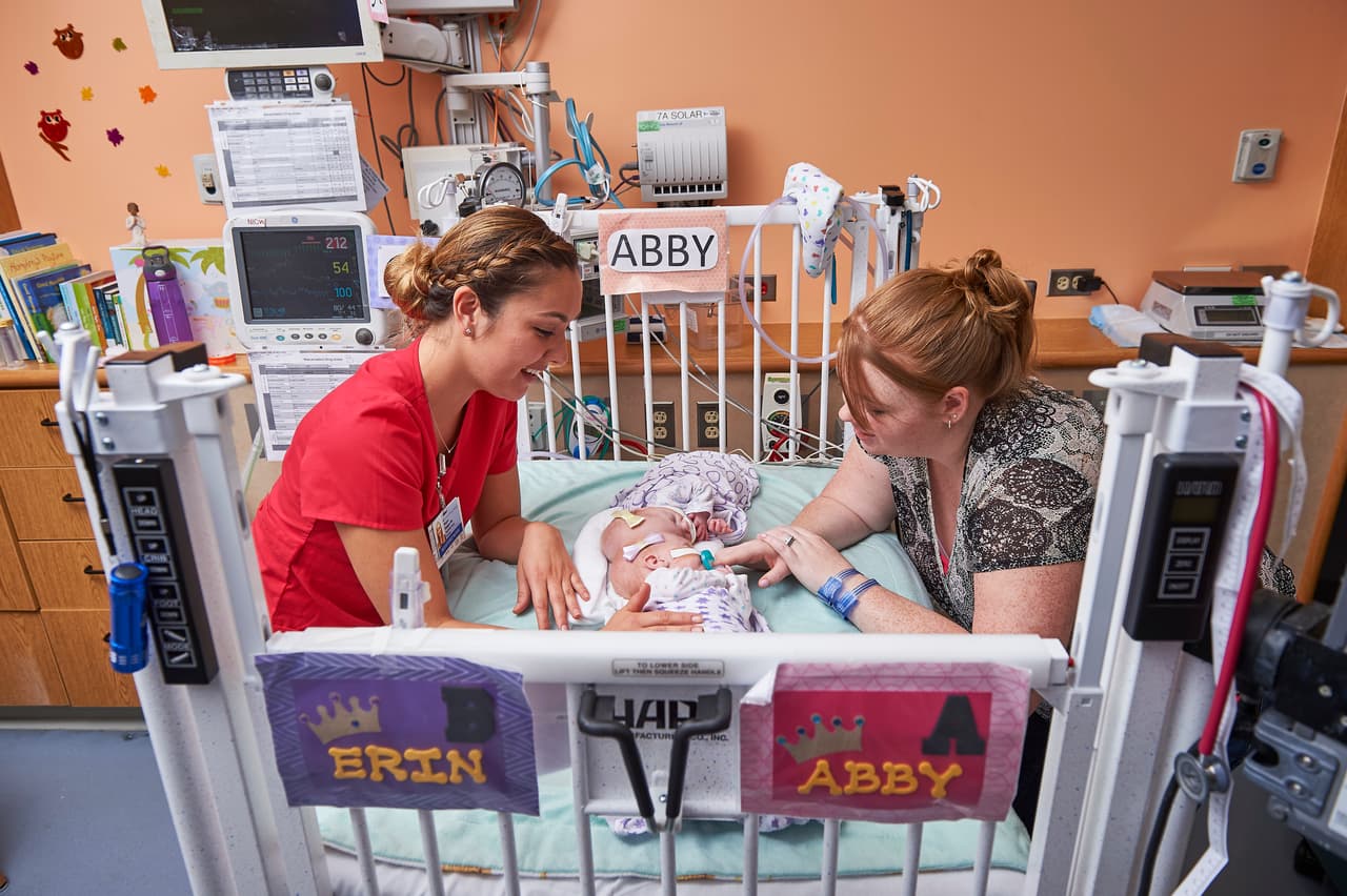 Heather Delaney y una enfermera del hospital de niños de Filadelfia cuidan de las pequeñas Erin y Abby, cuando tenían dos meses de nacidas, en septiembre de 2016. Luego de la operación las niñas se recuperan en la unidad pediátrica de cuidados intensivos del hospital.