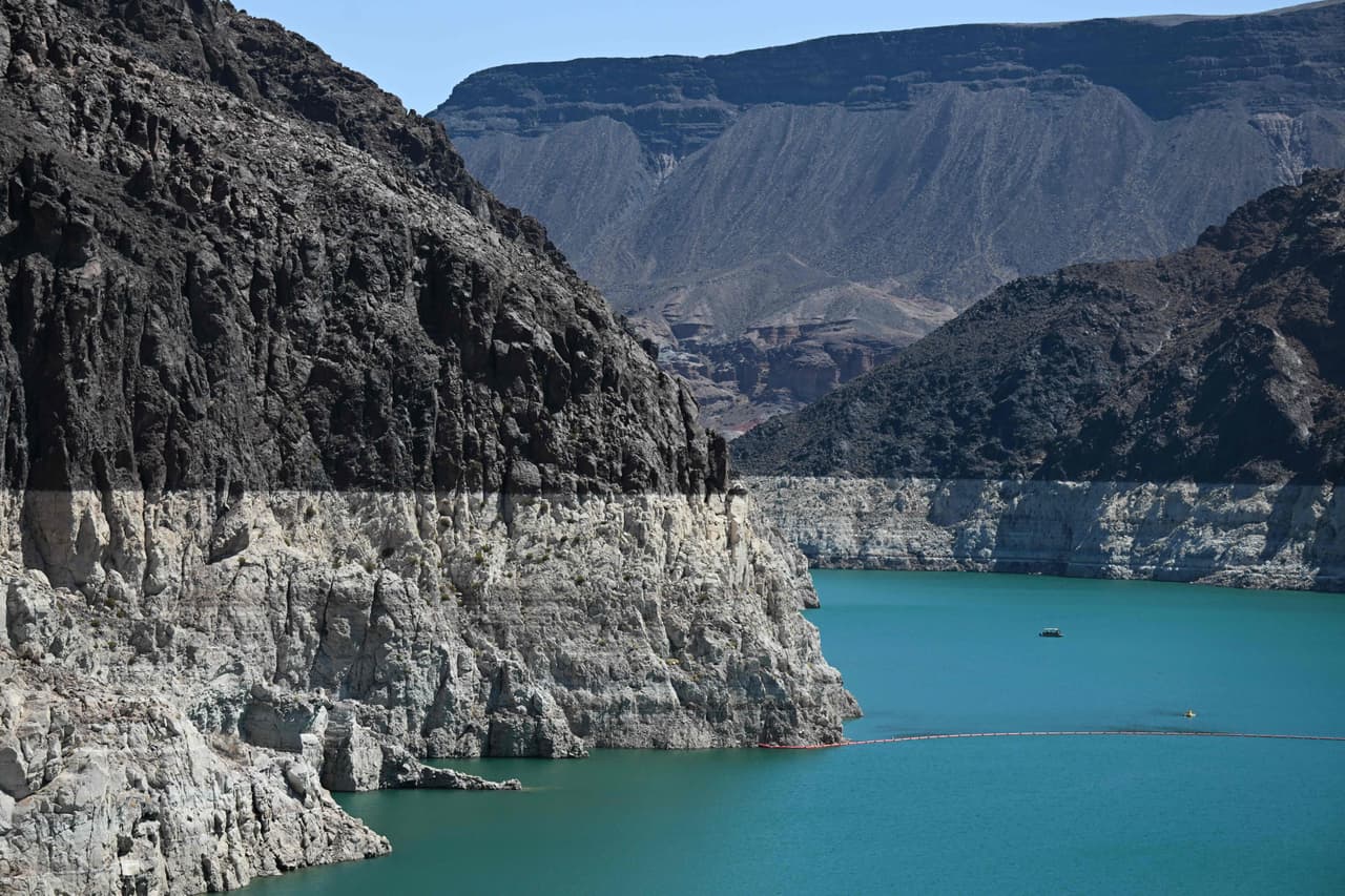 Una banda blanca de depósitos minerales que muestra los niveles de agua anteriores, es visible en el lago Mead a finales de junio de 2022 en la presa Hoover en el río Colorado en la frontera entre los estados de Nevada y Arizona. Millones de galones de agua del río Colorado se precipitan a través de la represa Hoover todos los días, generando electricidad para cientos de miles de hogares. Pero la megasequía que deseca el oeste de los Estados Unidos está haciendo que los niveles de los embalses caigan en picado hacia un punto muerto, el punto en el que la presa ya no puede producir energía.