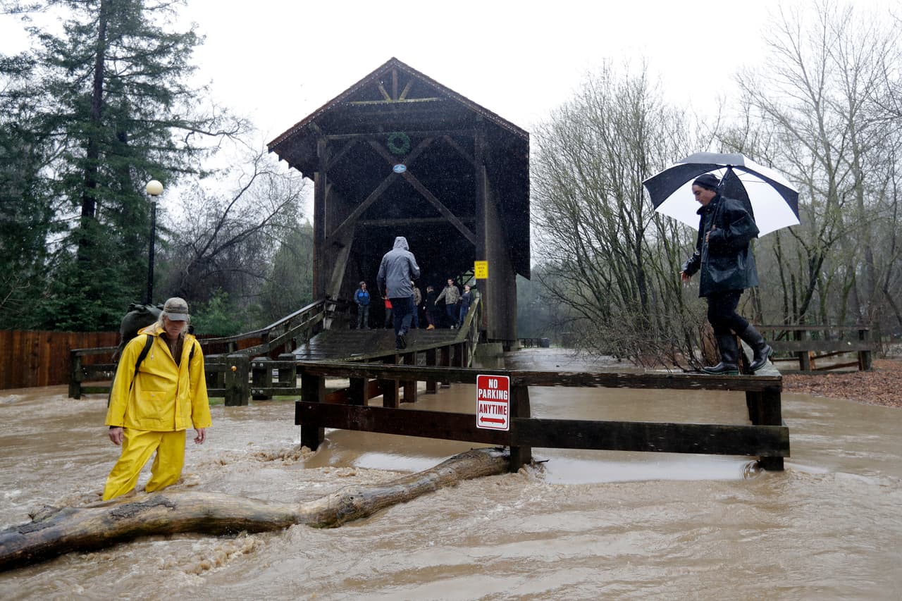 Residentes del Felton intentan cruzar un puente sobre el río San Lorenzo, aunque tienen que hacerlo caminando sobre la valla que antes servía como protección para evitar caer al río.