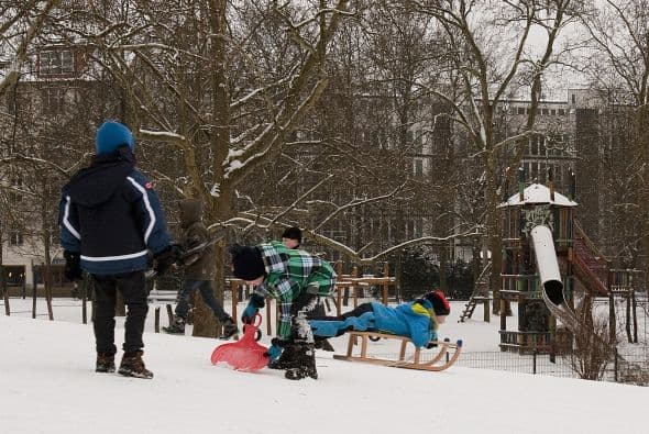Tras las nevadas los niños se divierten con trineos y otros utensilios en un parque de Berlín.