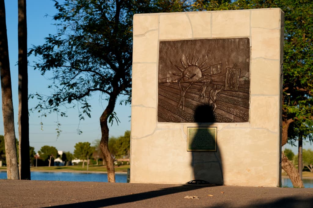 La sombra de una estatua de César Chávez se proyecta en medio de una plaza del Parque César Chávez, en homenaje al fundador del sindicato de Trabajadores Agrícolas Unidos, el miércoles 18 de marzo de 2026, en Laveen, Arizona.