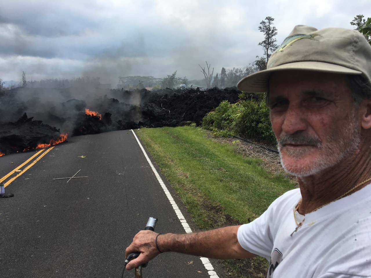 Sam Knox, un residente de Leilani Estates de 65 años, espera en su bicicleta frente a la ola de lava que se mueve en el vecindario. Los evacuados de esta zona han recibido permiso para volver a sus hogares para rescatar a sus mascotas o buscar sus medicamentos.