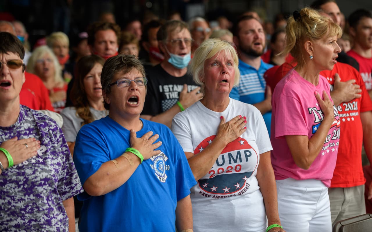 Los partidarios de Trump juran lealtad a la bandera mientras esperan la llegada del presidente al aeropuerto de Latrobe. Trump ganó Pensilvania en las elecciones de 2016 por un estrecho margen.