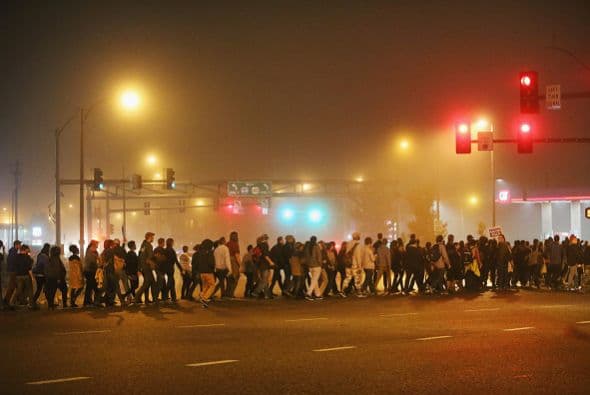 Posteriormente desfilaron por las calles de Ferguson hasta concentrarse frente a la estación de policía de la ciudad, donde los esperaba un cordón policial armado con cascos y escudos.