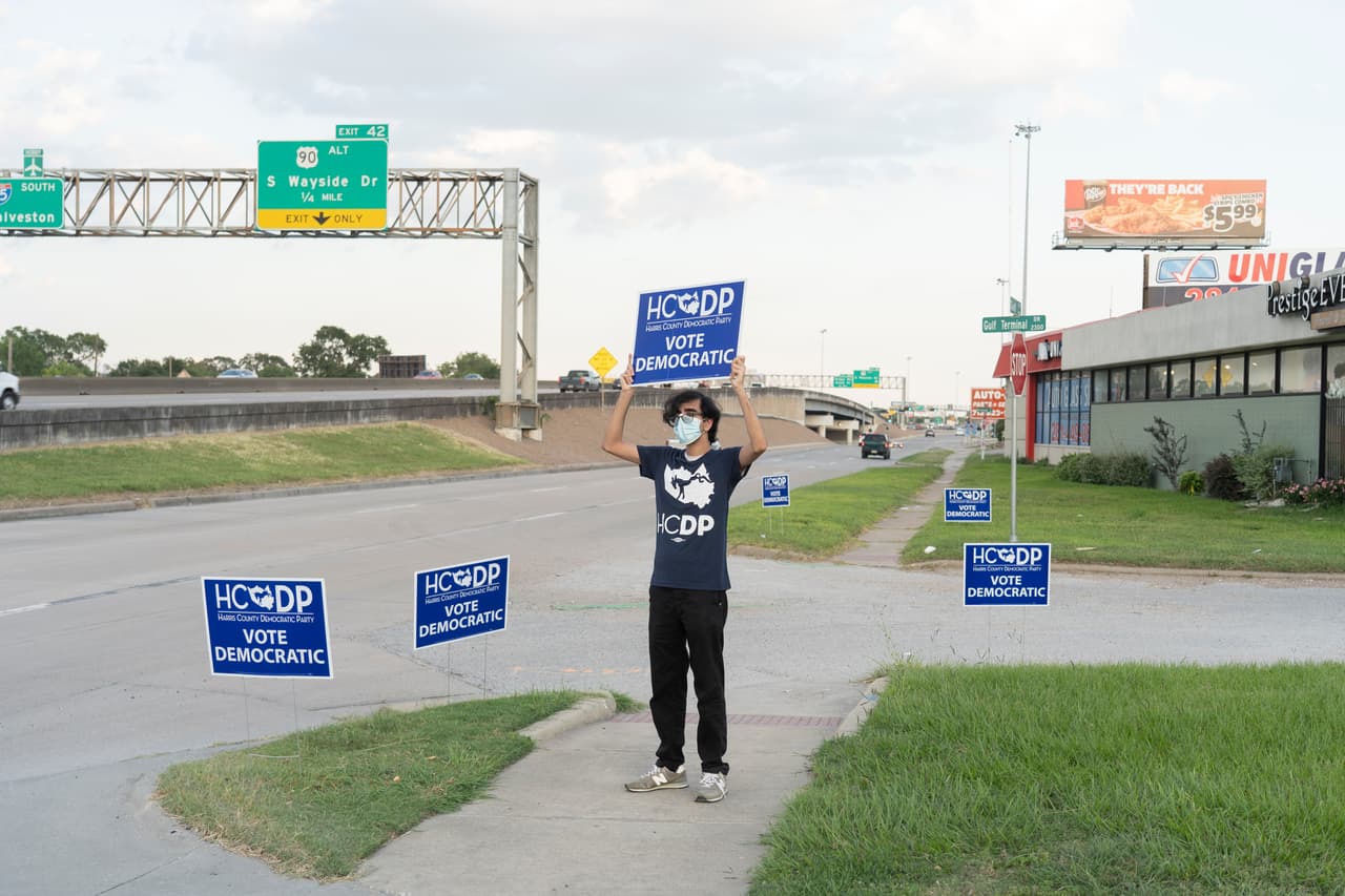 Un voluntario del Partido Demócrata en el condado de Harris (Houston) sostiene un letrero que invita a quienes lo deseen asistir a una proyección de la Convención Nacional Demócrata, el 20 de agosto de 2020. Este año, la convención se organizó de forma virtual.