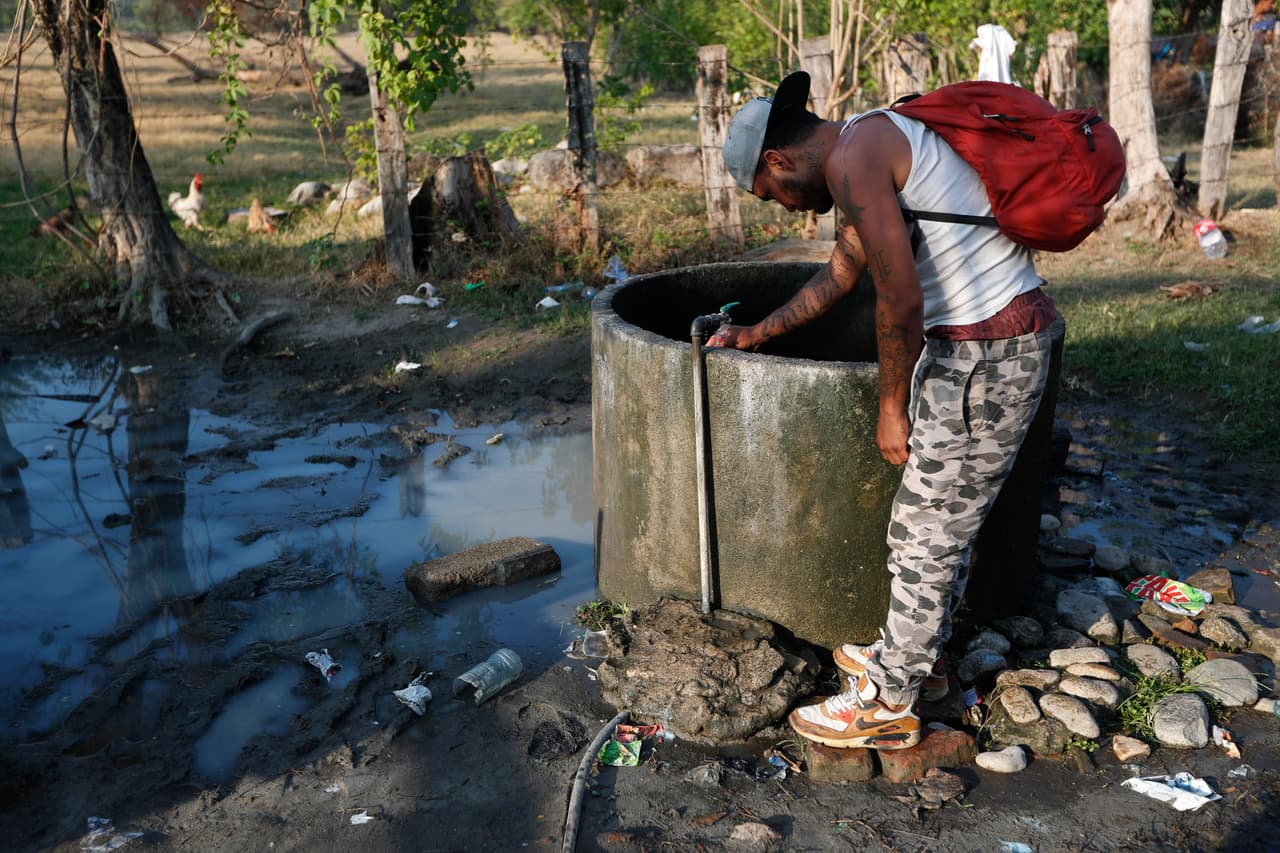 Un migrante centroamericano llena su botella de agua de un grifo en una granja de animales en Mapastepec. El sacerdote Heyman Vázquez, párroco en Huixtla, municipio de la misma ruta, dijo a AP que las razones por las que la solidaridad ha disminuido se debe a
<b>"la campaña de discriminación y xenofobia que se está creando a través de las redes sociales y los medios que culpan a los migrantes de la inseguridad en Chiapas”.</b>
