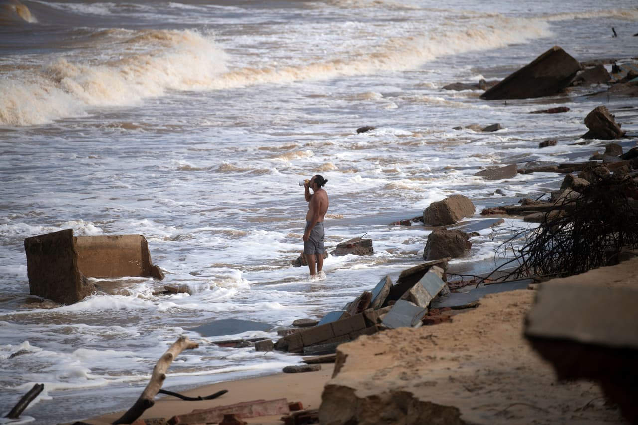 Un hombre bebe cerveza en la playa de Atafona.