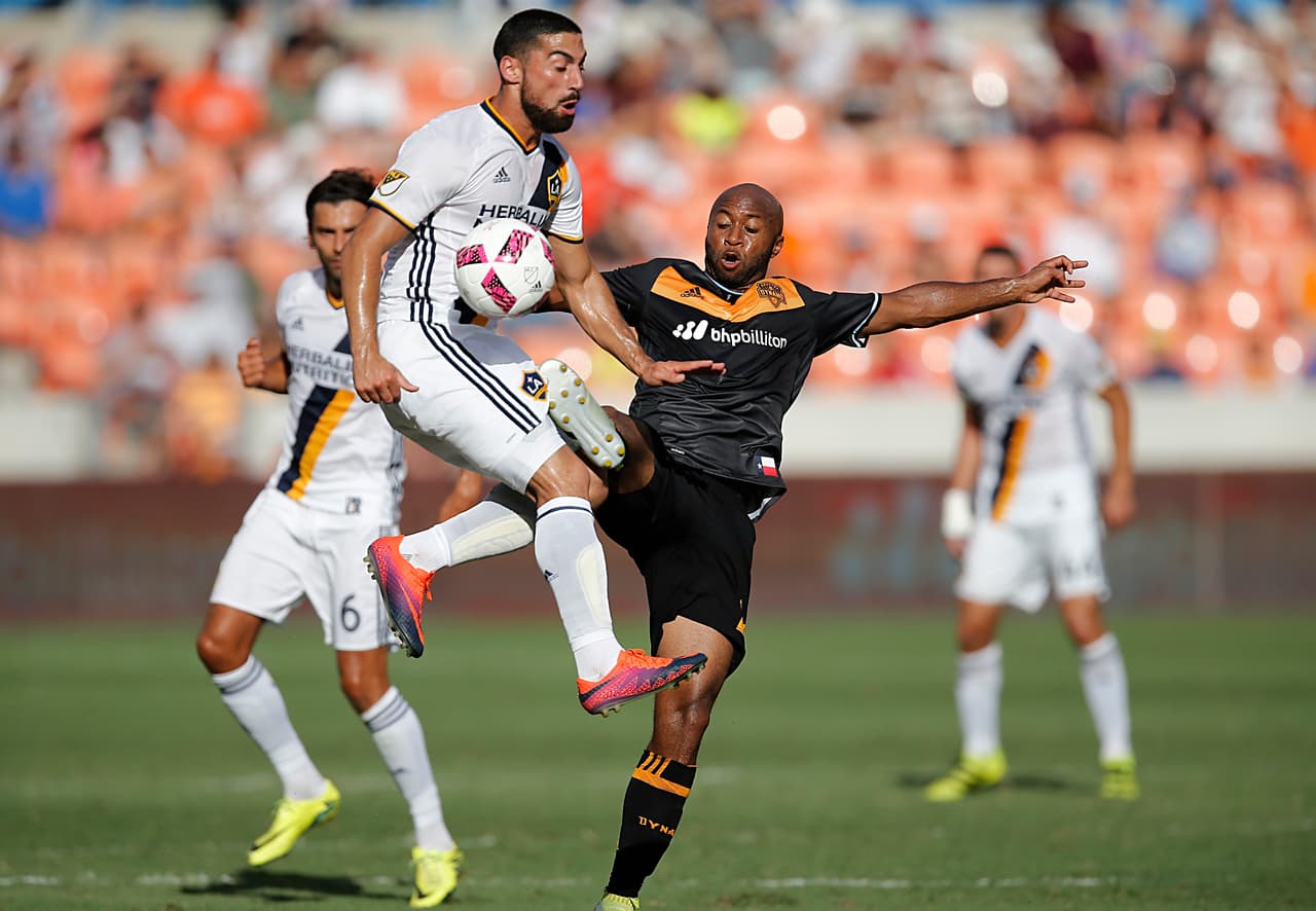Oct 16, 2016; Houston, TX, USA; Los Angeles Galaxy forward Giovani dos Santos (10) and Houston Dynamo midfielder Collen Warner (26) battle for the ball in the first half at BBVA Compass Stadium. Mandatory Credit: Thomas B. Shea-USA TODAY Sports