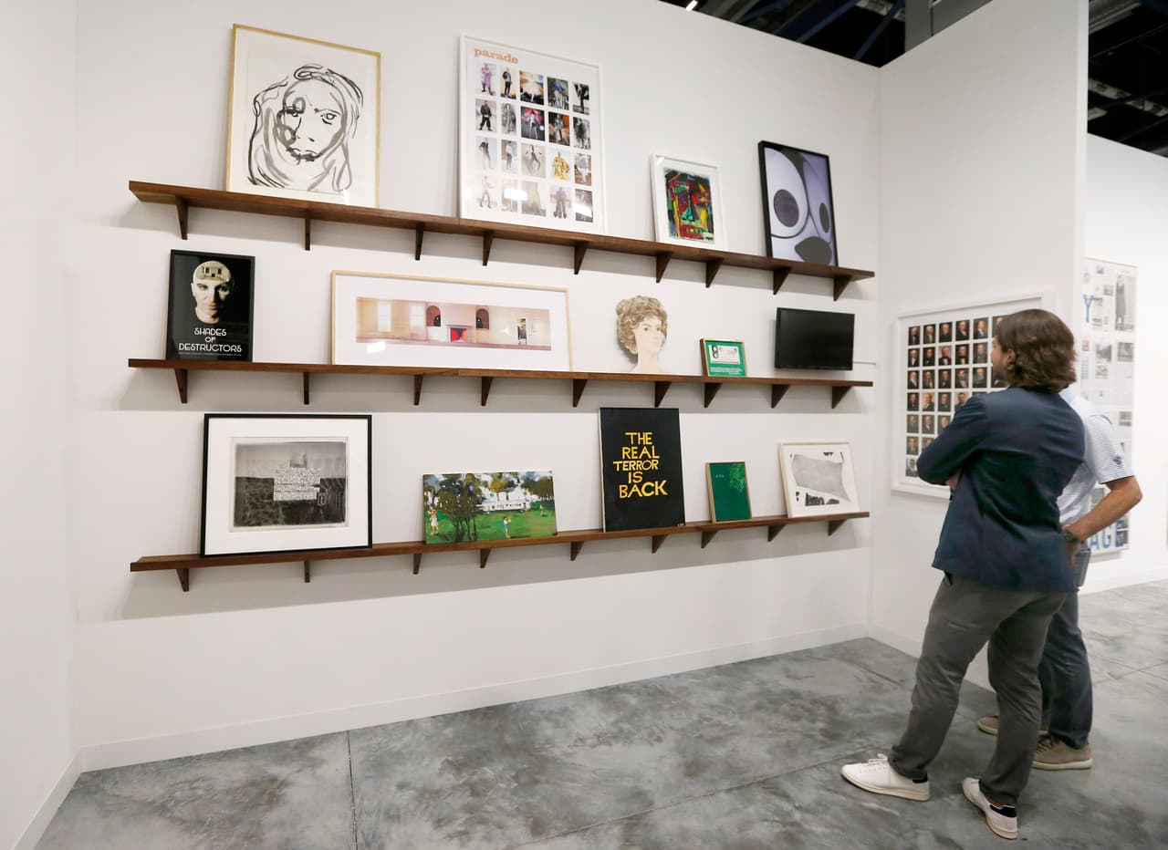 Art patrons walk through a gallery during Art Basel in Miami on November 30, 2016. Art Basel represents over 250 art galleries at the Miami Beach Convention Center and is considered one of the world's largest art festivals with art events throughout the city. / AFP / RHONA WISE / RESTRICTED TO EDITORIAL USE - MANDATORY MENTION OF THE ARTIST UPON PUBLICATION - TO ILLUSTRATE THE EVENT AS SPECIFIED IN THE CAPTION (Photo credit should read RHONA WISE/AFP/Getty Images)