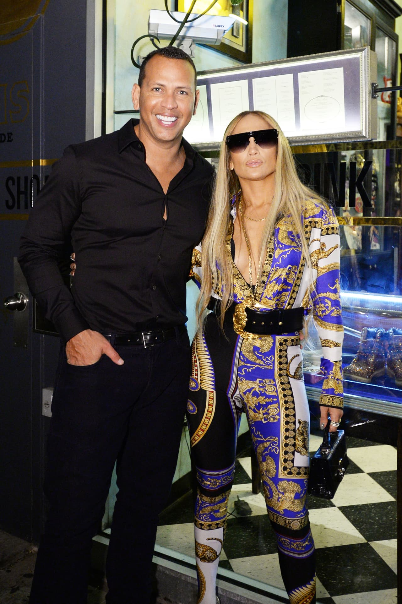 Luego de que había usado ese diseñador para todos los vestuarios de sus performances, JLo eligió una
<a href="https://www.versace.com/us/en-us/women/clothing/blouses-tops/signature-pillow-talk-silk-shirt-a7900/A79153-A226711_A7900.html#q=signature%2Bprint%2Bshirt&start=1">camisa</a> de manga larga y botones en oro con el logo de la medusa confeccionada en el estampado Pillow Talk, insignia de la marca y unos ajustadísimos
<a href="https://www.modaoperandi.com/versace-pf18/matte-lycra-leggings-5">leggings</a> en lycra mate de cintura alta y que cubren hasta los pies. Todo en azul, blanco y dorado. Remató con un cinturón negro de la misma marca, lentes oscuros Alien de la marca británica
<a href="https://www.fasforartssake.com/collections/all/products/alien-black">For Art’s Sake</a> y el icónico bolso de Jason Stalvey.