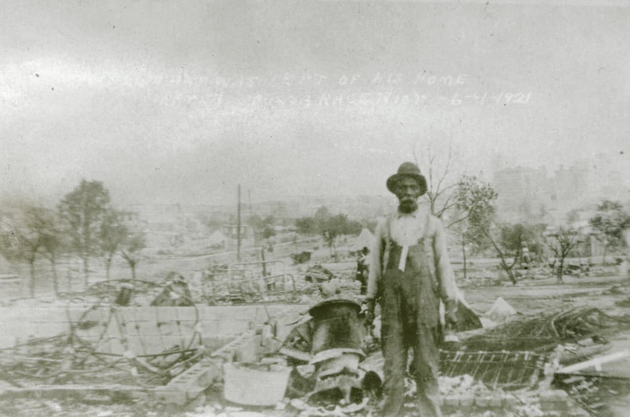 <b>Un sobreviviente de la tragedia cerca de las ruinas de su casa.</b> 
<br>
<br>El distrito de Greenwood de Tulsa era conocido como ‘Black Wall Street’. La comunidad negra contaba con más de 300 negocios prósperos, dos teatros, médicos y farmaceutas.