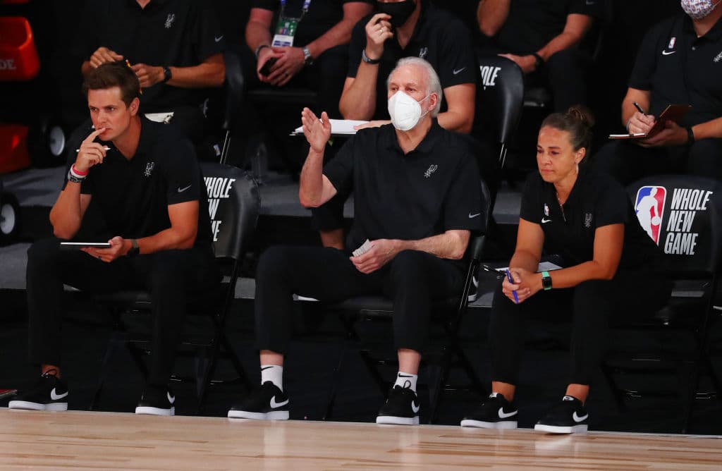 Gregg Popovich, entrenador de los San Antonio Spurs de la NBA usa una mascarilla durante un juego contra los Sacramento Kings en Florida.