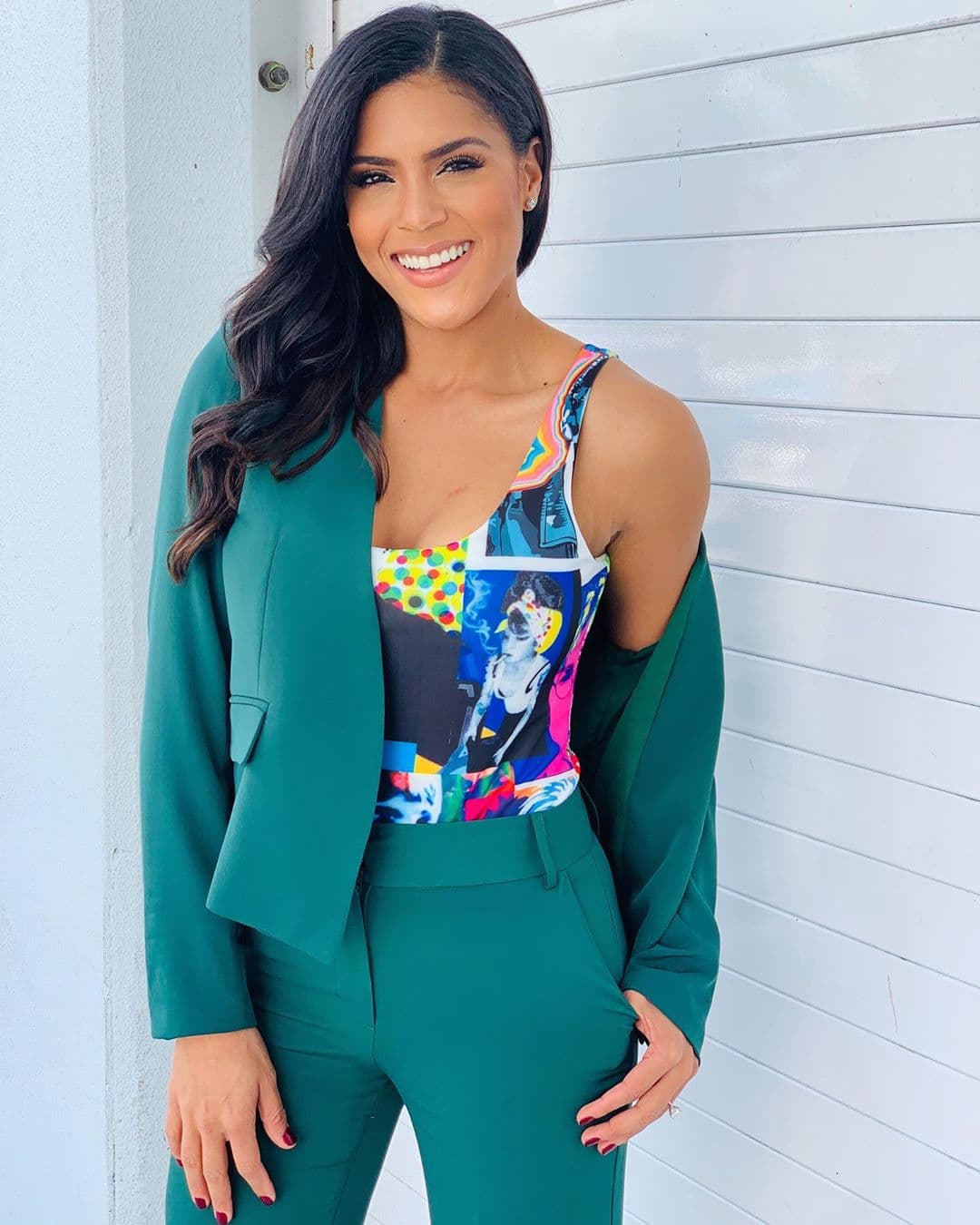 El estilo anterior la ha acompañado en más de una ocasión y aquí la vemos usándolo como blusa interior para un traje sastre en color verde.