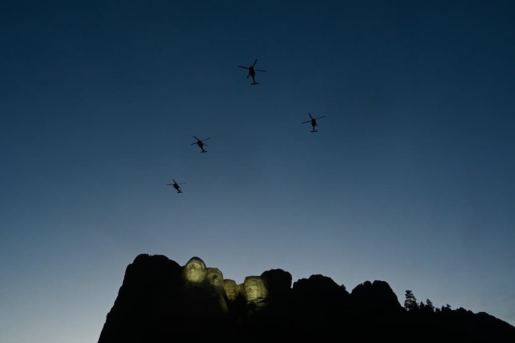 Helicópteros UH-60 Black Hawk sobrevuelan la zona mientras el secretario del Interior, Doug Burgum, habla ante el presidente Donald Trump en el Monumento Nacional Monte Rushmore, el viernes 3 de julio de 2026, cerca de Keystone, Dakota del Sur. (Foto AP/Matt Gade)