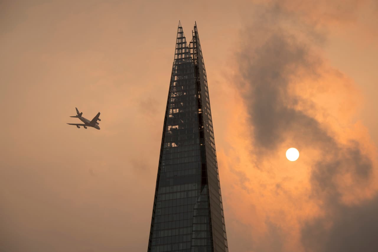 Un avión vuela cerca de la torre Shard en el centro de Londres.