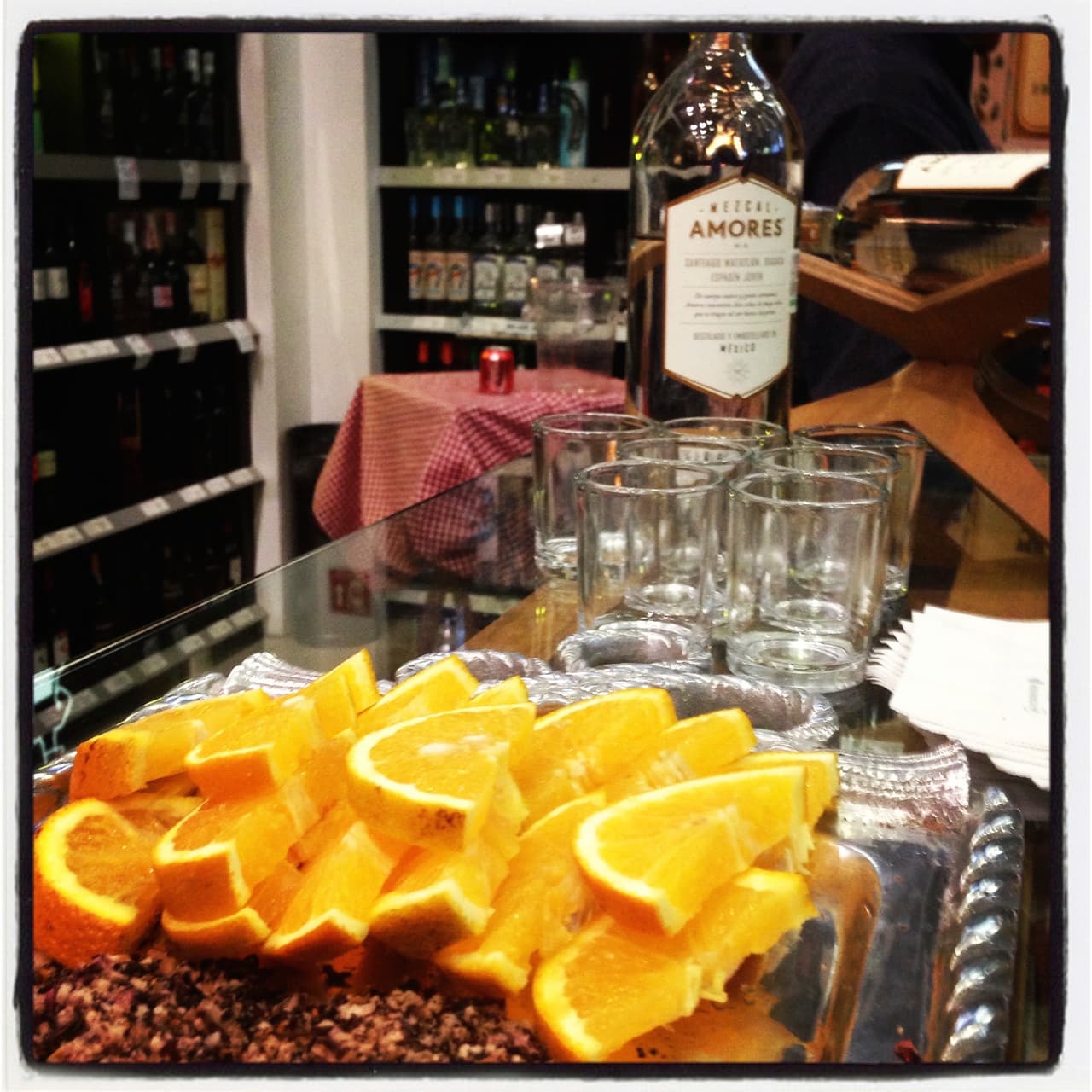 Mezcal listo para servirse acompañado de naranjas