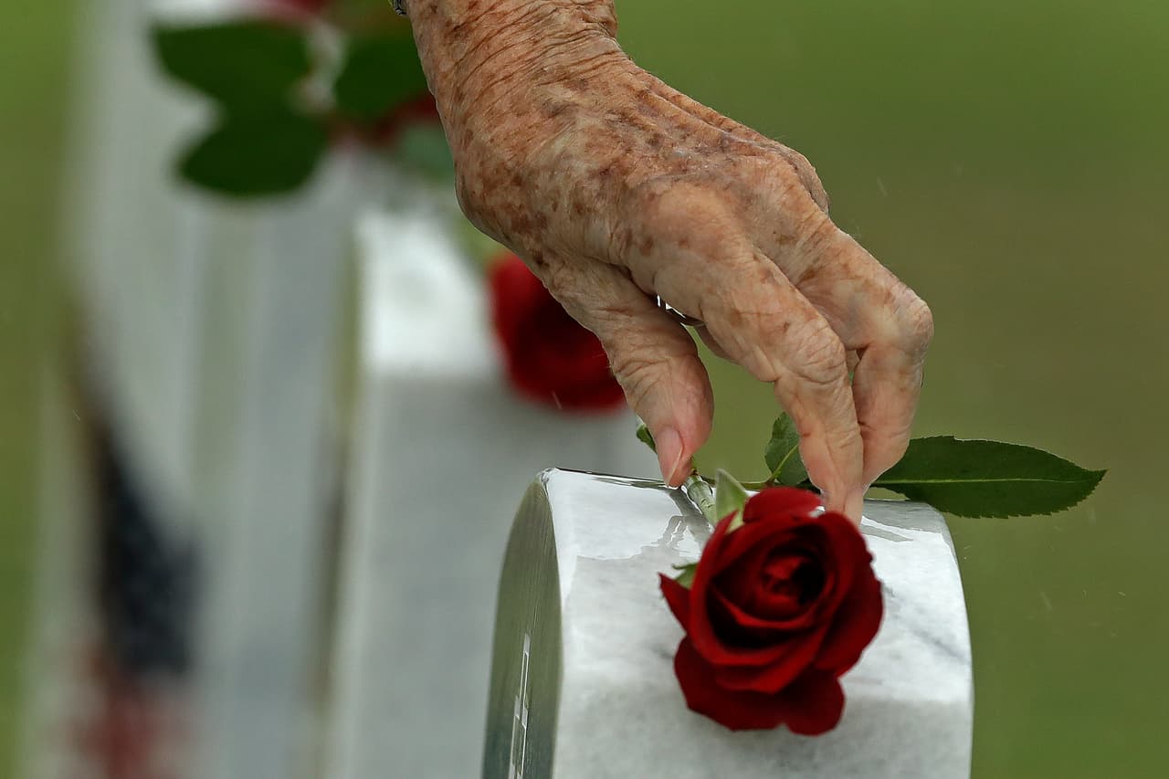 Una mujer coloca una rosa en una lápida para el Día de los Caídos en el Cementerio Nacional de Cabo Cañaveral en Mims, Florida.
