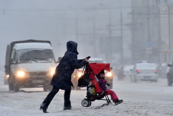 Esta mujer empuja una carreola con dificultades por la nieve acumulada en los caminos en Moscú.