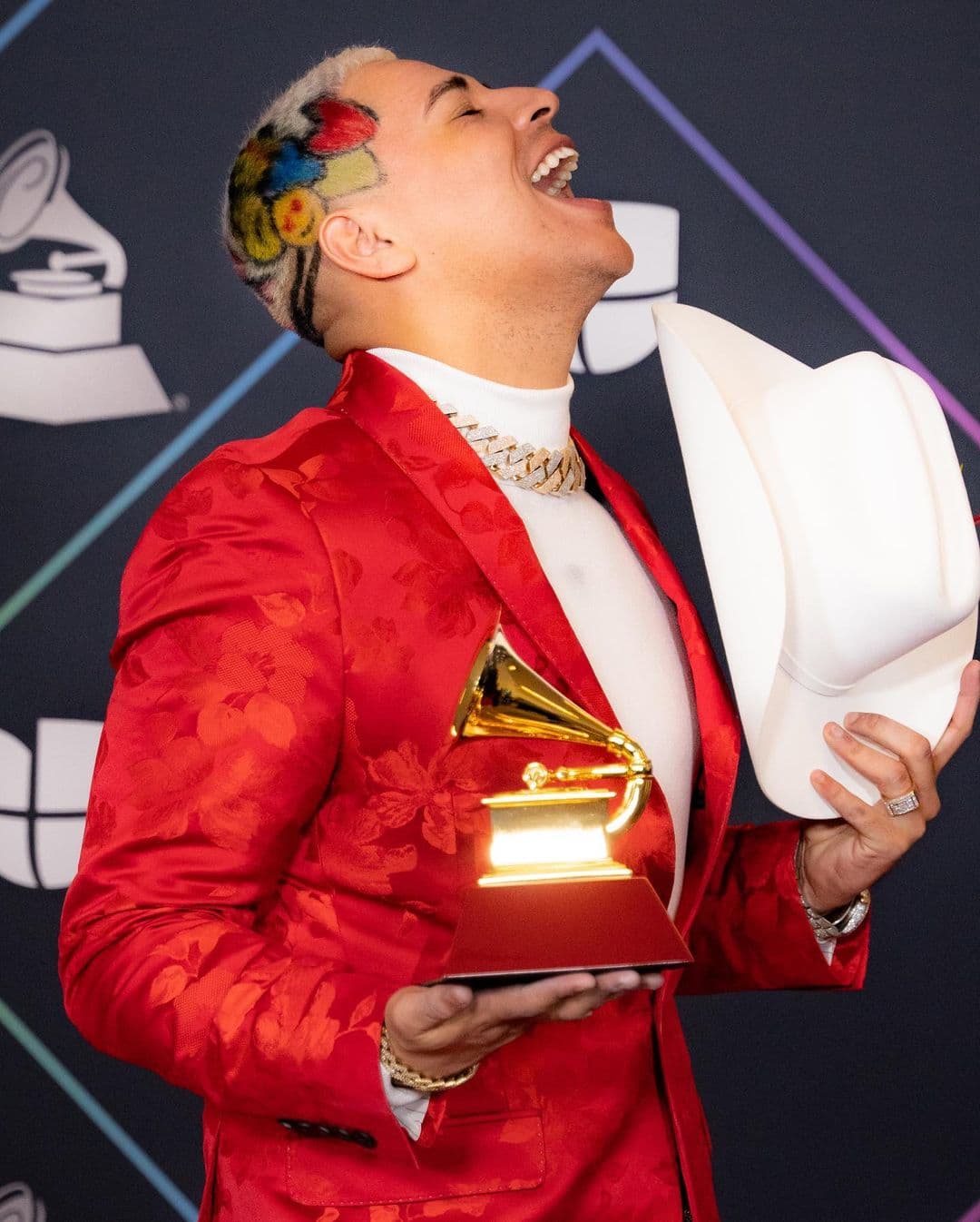 <a href="https://www.univision.com/radio/raul-brindis/bien-delineadita-eduin-caz-muestra-como-le-depilan-las-cejas-video">Eduin Caz</a>, vocalista de Grupo Firme, acostumbra teñir una parte de su cabello con un mechón, pero para los Latin GRAMMY, fue más allá y se hizo un diseño con corazones de colores y una carita sonriente.
<br>