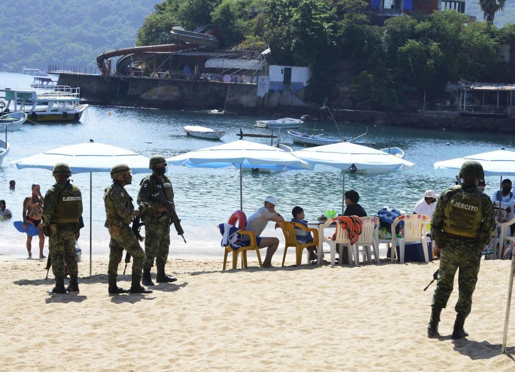 Las turísticas playas que se encuentran en Acapulco ahora representan un peligro para muchos viajeros debido a que el lugar ha sido azotado en los últimos años por grupos de la delincuencia organizada, que se dedican al narcotráfico y la extorsión. 
<br>
<br>En la imagen, miembros de la Policía y el Ejército Mexicanos custodian la playa Caleta y Caletilla.