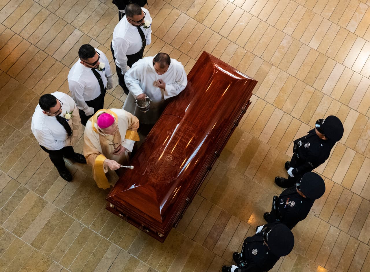 El ataúd del oficial es rociado con agua bendita antes del ser custodiado fuera de la catedral y ser transladado al cementerio Forest Lawn en Hollywood Hills.