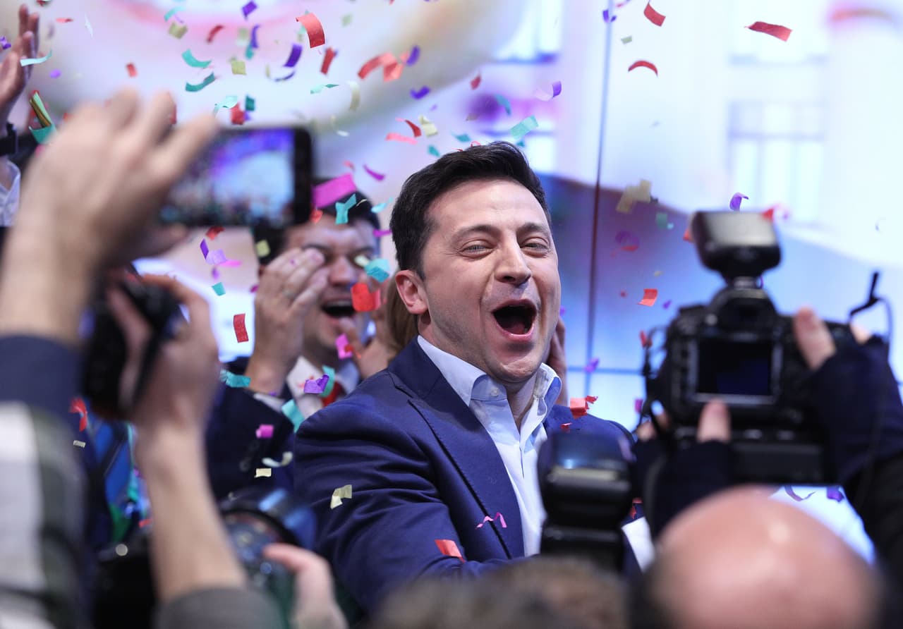 <b>La llegada de Zelenskyy y el primer juicio político a Trump (2019)</b>
<br>
<br>El comediante y actor Volodymyr Zelenskyy fue elegido presidente en abril. Durante su campaña prometió hacer las paces con los rusos y poner fin a la guerra en Donbas.
<br>
<br>Sus primeros esfuerzos para aplacar la violencia se ven frenados por el presidente Trump, quien bloqueó brevemente la ayuda militar estadounidense a Ucrania.
<br>
<br>En una llamada telefónica con Trump en julio de 2019, Trump le pidió a Zelenskyy que investigara a la empresa energética Burisma y su relación con los Biden, a cambio de la ayuda militar. Esto llevó al primer juicio político al presidente Trump, en diciembre de 2019.
<br>