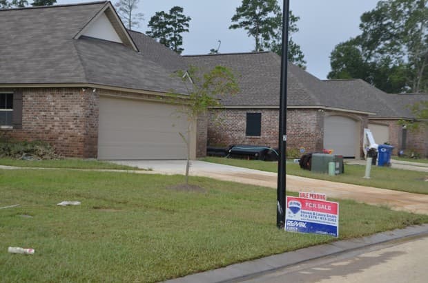 Las marcas de la altura de las aguas en casas en venta en Magnolia Farms, una zona de inundación designada por FEMA.