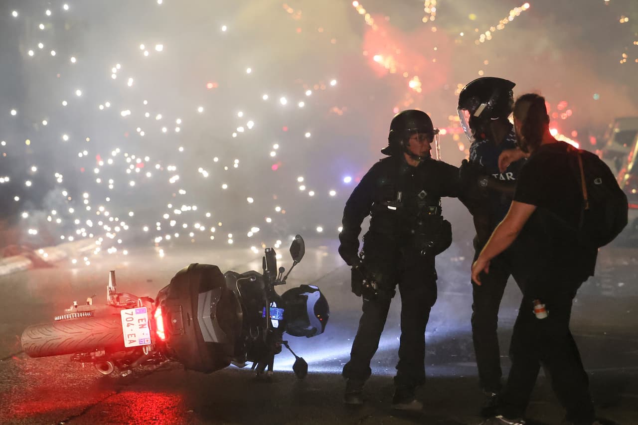 Entre humo y fuegos artificiales, la policía trata de desalojar a aficionados del PSG que celebraban el campeonato europeo en la capital francesa.