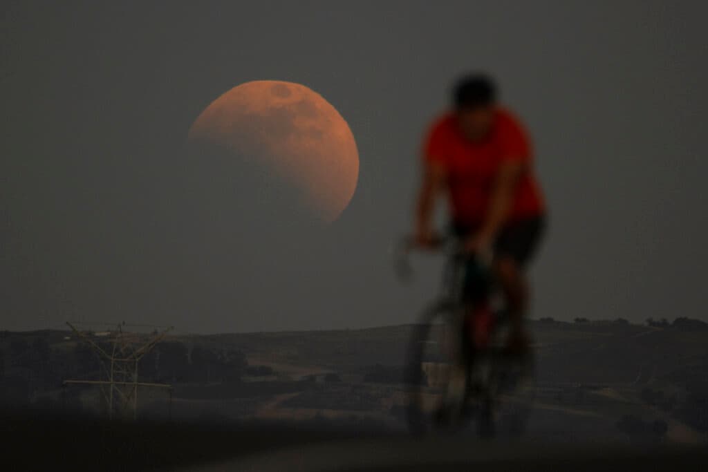 El comienzo del eclipse lunar de 
<a href="https://www.univision.com/temas/superluna">superluna</a> detrás de este ciclista en Irwindale, California.