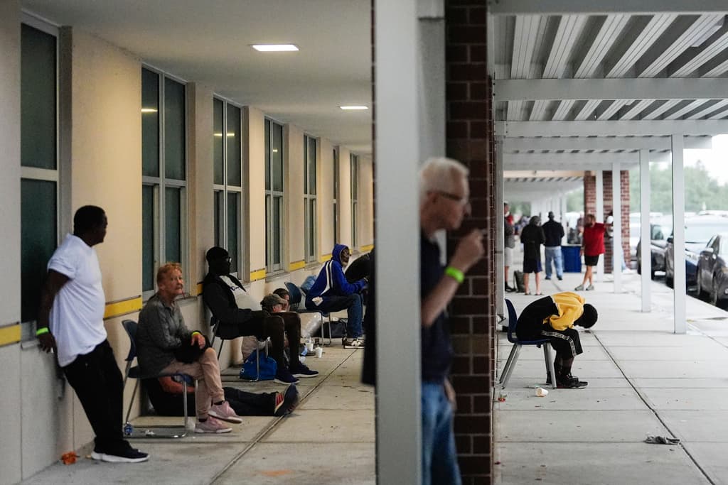 <b>Toman aire antes de encerrarse: </b>La gente disfrutaba del aire fresco en el exterior de la escuela secundaria Gibbs, un refugio del gobierno donde 1,700 personas ya habían buscado refugio a última hora de la mañana del miércoles 9 de octubre de 2024, antes de la llegada del huracán Milton a San Petersburgo, Florida.