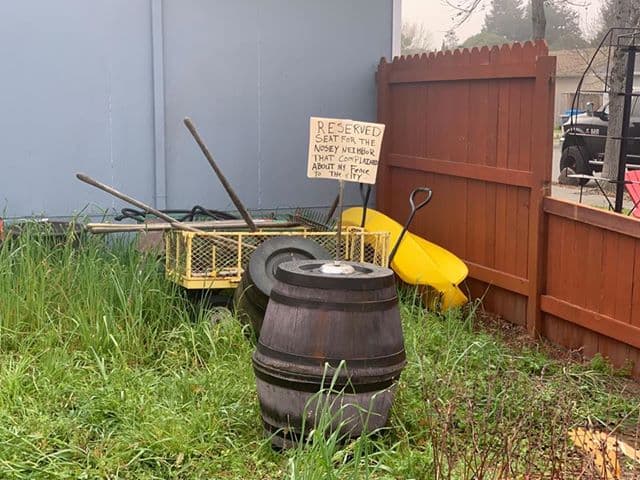 "Un asiento reservado para el vecino entrometido que se quejó de mi cerca a la ciudad", dice el cartel en el jardín de los Windus.