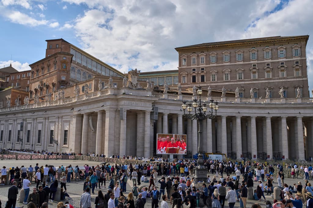 Los fieles observan las imágenes del cónclave hoy, miércoles 7 de mayo de 2025, en una pantalla gigante en la Plaza de San Pedro del Vaticano.