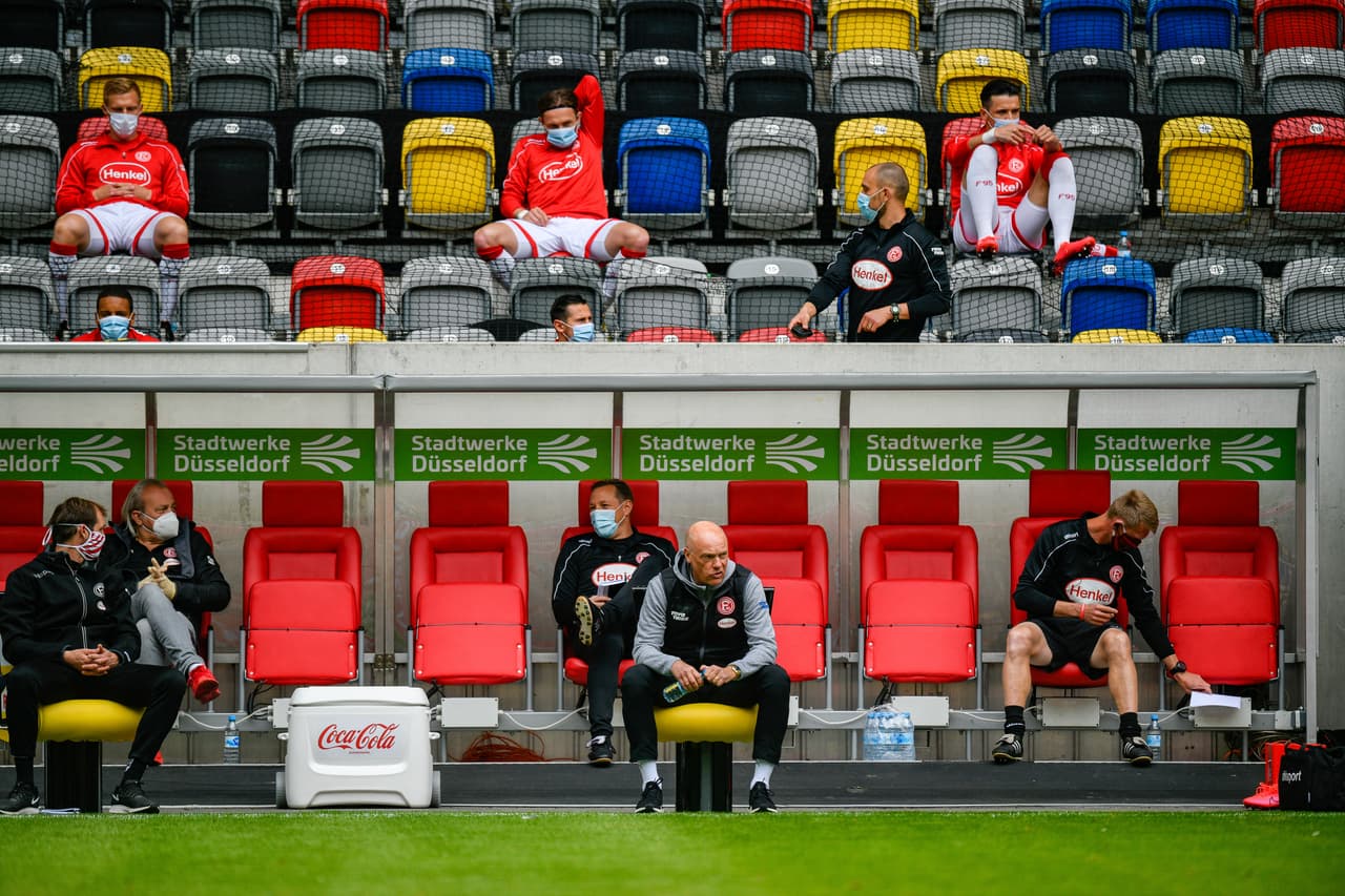 - Uwe Roesler, entrenador del Fortuna Duesseldorf, sentado por delante de su cuerpo técnico en el Merkur Spiel-Arena.
<br>- Los jugadores están detrás del banquillo, en las gradas permanecen antes de ser solicitados para calentar o ingresar de cambio.