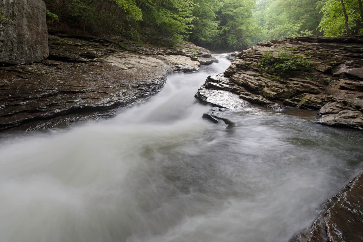<b>Pennsylvania.</b>
<br>
<br>El arroyo
<a href="https://ohiopyle.org/meadow-run-natural-waterslides-area/" target="_blank">Meadow Run (Medow Run Creek), en el Parque Estatal Ohiopyle</a>, tiene suelos de roca arenisca que forman un tobogán de agua natural curvo y de rápido movimiento que termina en una profunda piscina de agua. El área está rodeada de formaciones rocosas cubiertas de musgo y zonas para realizar caminatas.
<br>