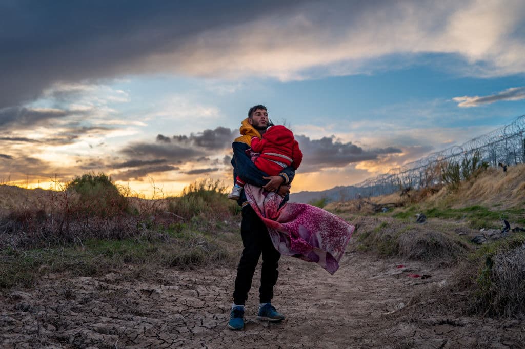 El migrante peruano Jordan y su hija de 1 año Briana esperan para cruzar a EEUU, el 26 de marzo, cerca de El Paso, Texas, mientras cientos de migrantes que buscaban asilo se enfrentaron con guardias texanos mientras buscaban entregarse a la patrulla fronteriza.
<a href="https://www.univision.com/noticias/inmigracion/texas-gobierno-federal-puesta-marcha-ley-antiinmigrante-sb4-corte">La Ley Senatorial 4, la SB4 de Texas,</a> que permitía a fuerzas estatales arrestar migrantes por sospechas de cruces ilegales, se puso en vigor brevemente en esos días. Tras idas y vueltas legales, la ley antiinmigrante quedó suspendida.