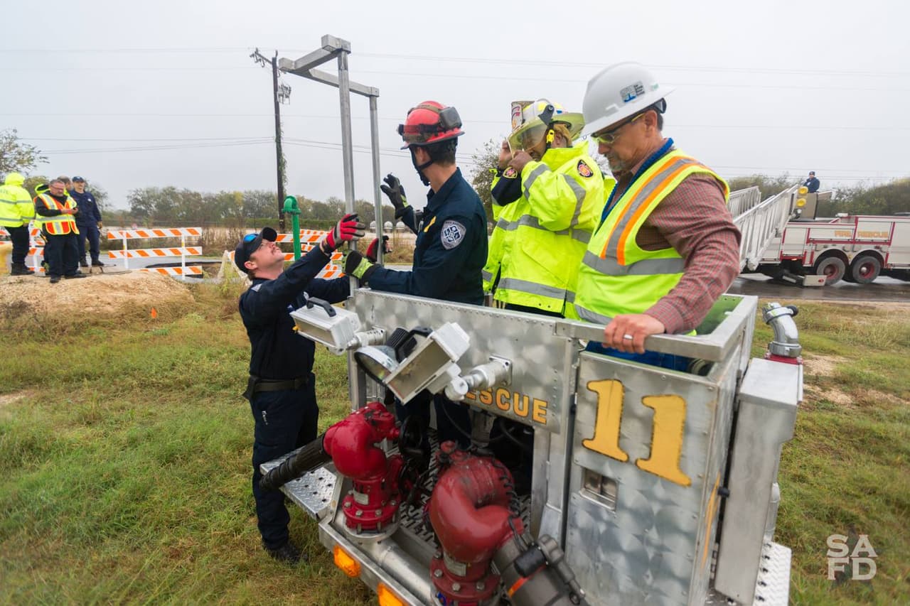 Rescatistas y bomberos se alistan para iniciar la operación de extracción de los vehículos del sumidero.