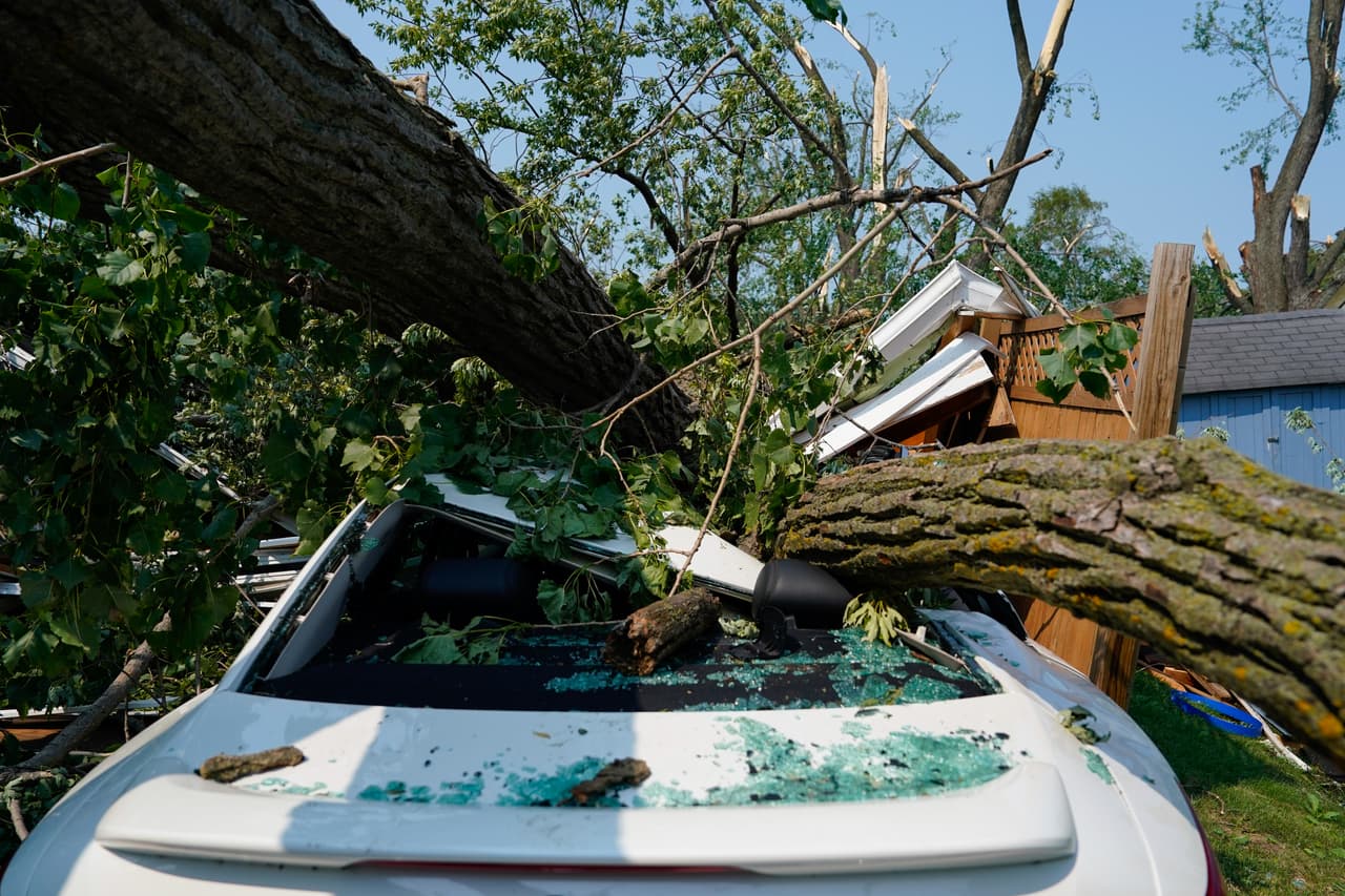 Un automóvil yace aplastado bajo un árbol caído después de que un tornado azotara la zona el día anterior en Appleton, Wisconsin, el martes 28 de julio de 2026.