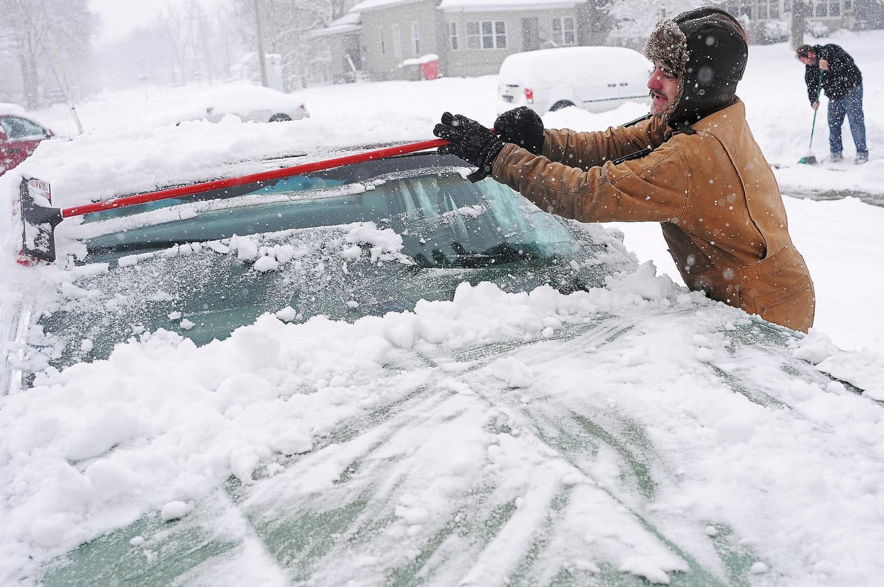Un hombre limpia la nieve de su vehículo en Sioux Falls, en South Dakota.