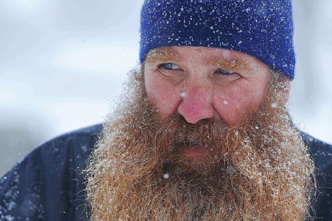 La nieve cubre la barba de un cartero mientra reparte el correo en Sioux Falls, en South Dakota.
