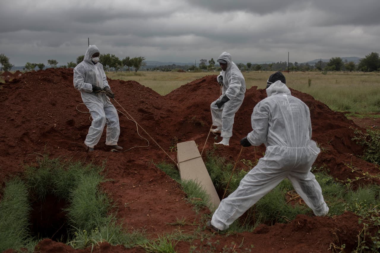 Los trabajadores de la morgue enterraron el ataúd de un hombre no identificado en una "tumba pobre" en un cementerio de Olifantsvlei en las afueras de Johannesburgo. (Foto AP / Bram Janssen)