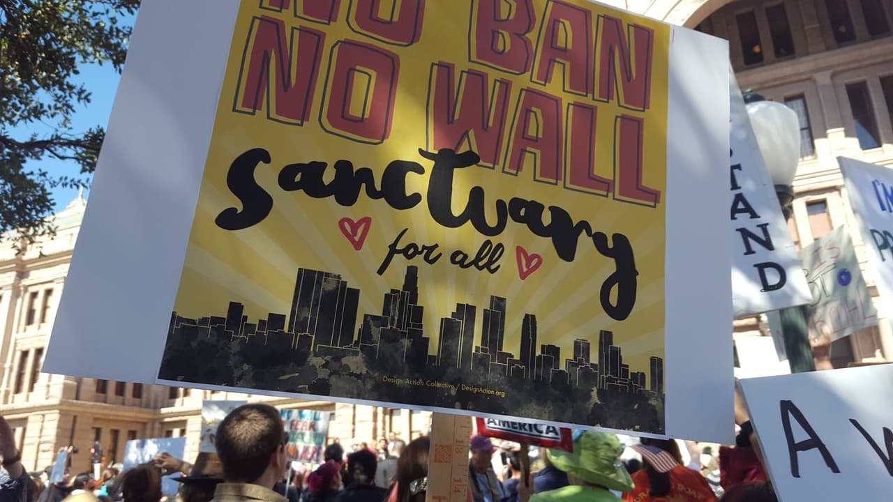 Mensaje: “Sin restricciones, sin muro. Un santuario para todos”, sobre una representación de la vista aérea de la ciudad de Austin. 
<br>
