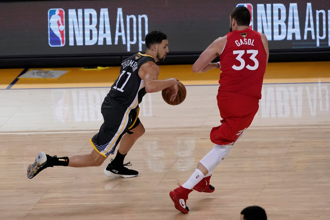 Klay Thompson (11) siguió desquiciando a los Toronto Raptors. Aquí el poste español Marc Gasol (33) buscando usar su altura para incomodarle los triples.