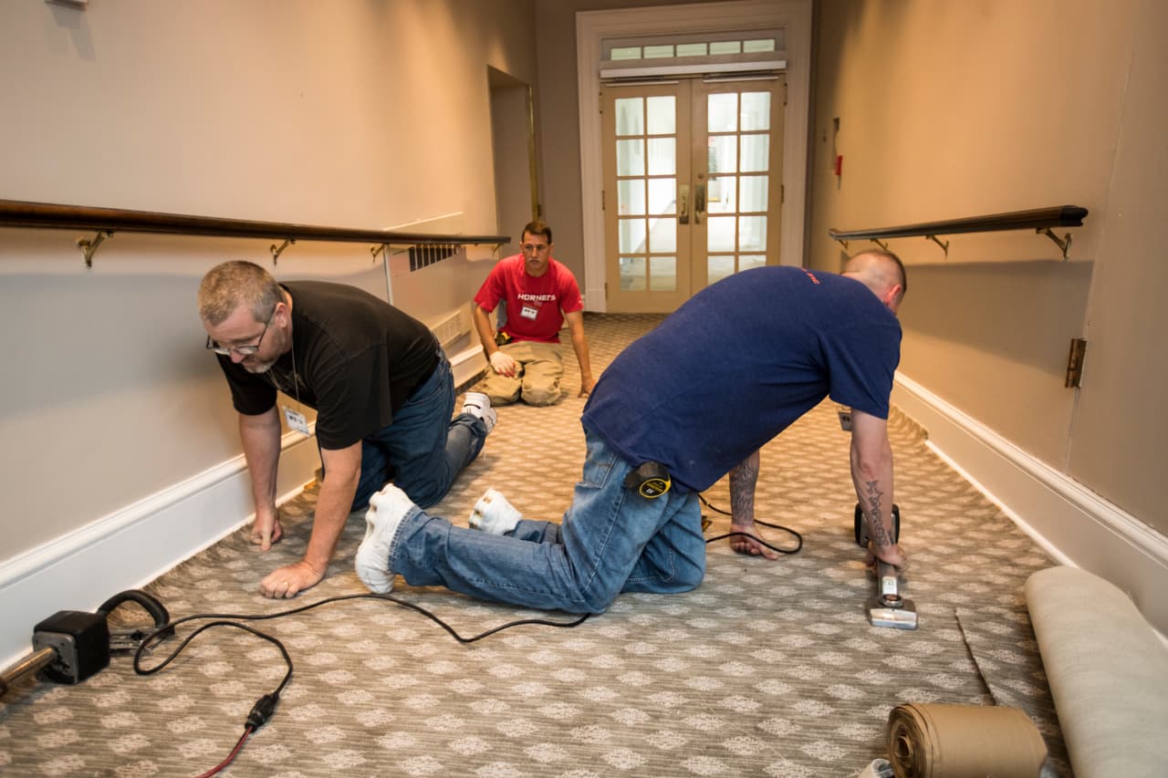 Trabajadores instalan una alfombra nueva en un pasillo del Ala Oeste.